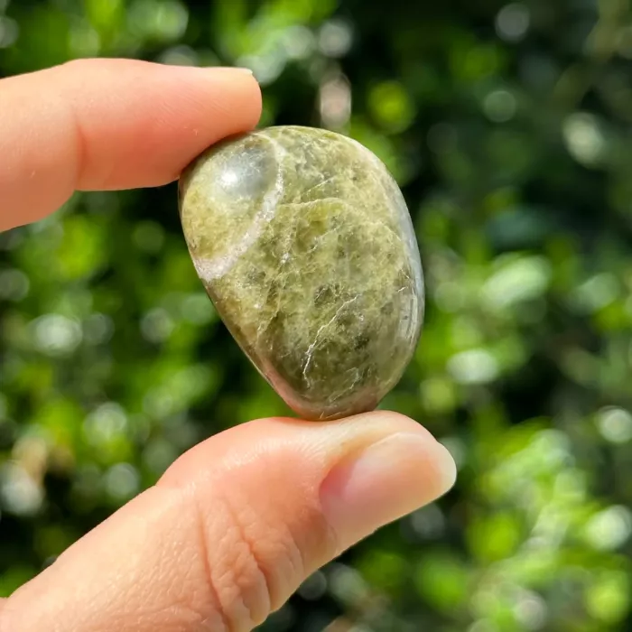 Vésuvianite roulée entre les doigts