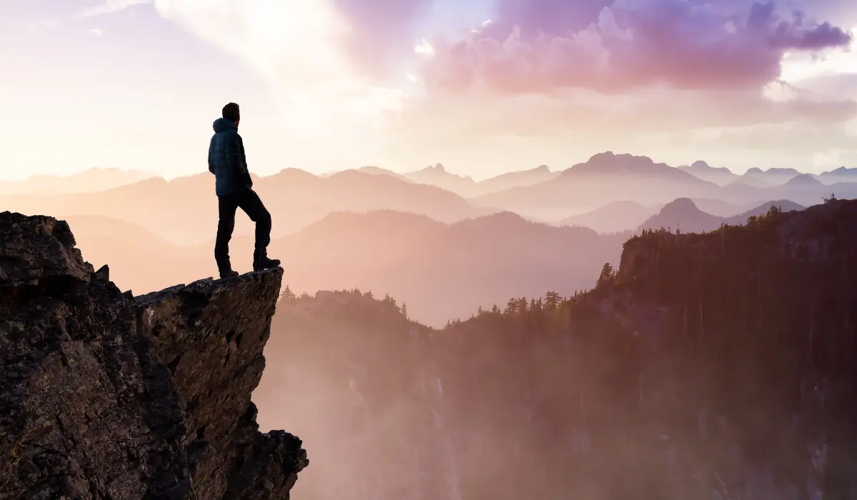 Homme au bord d'un point de vue, symbolisant l'accomplissement