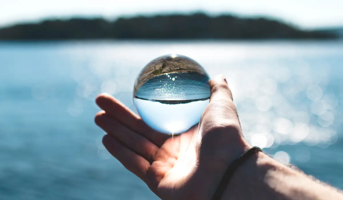 Sphère en verre devant un lac pour illustrer la clarté de 18