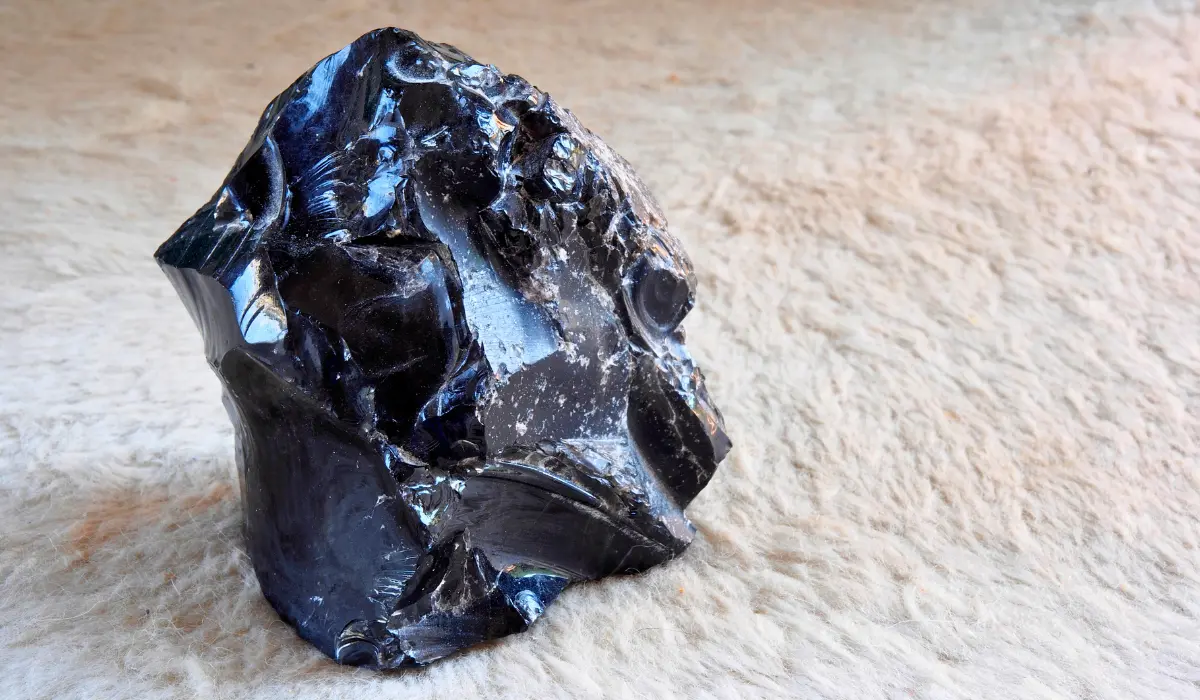 Obsidienne dorée brute posée sur un tapis