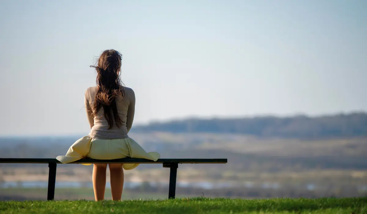 Jeune femme cherchant le silence sur un banc