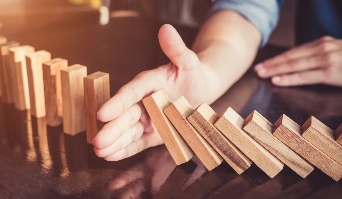 Personne stoppant une chute de domino, pour illustrer le changement lié au chiffre 25