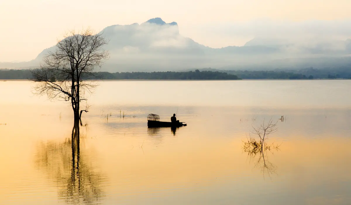 homme sur une barque au milieu d'un lac