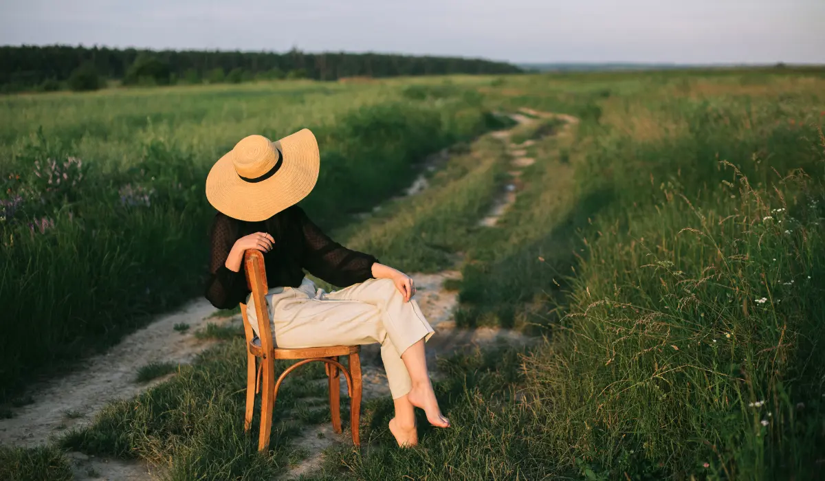 jeune femme méditant assise près d'un champ