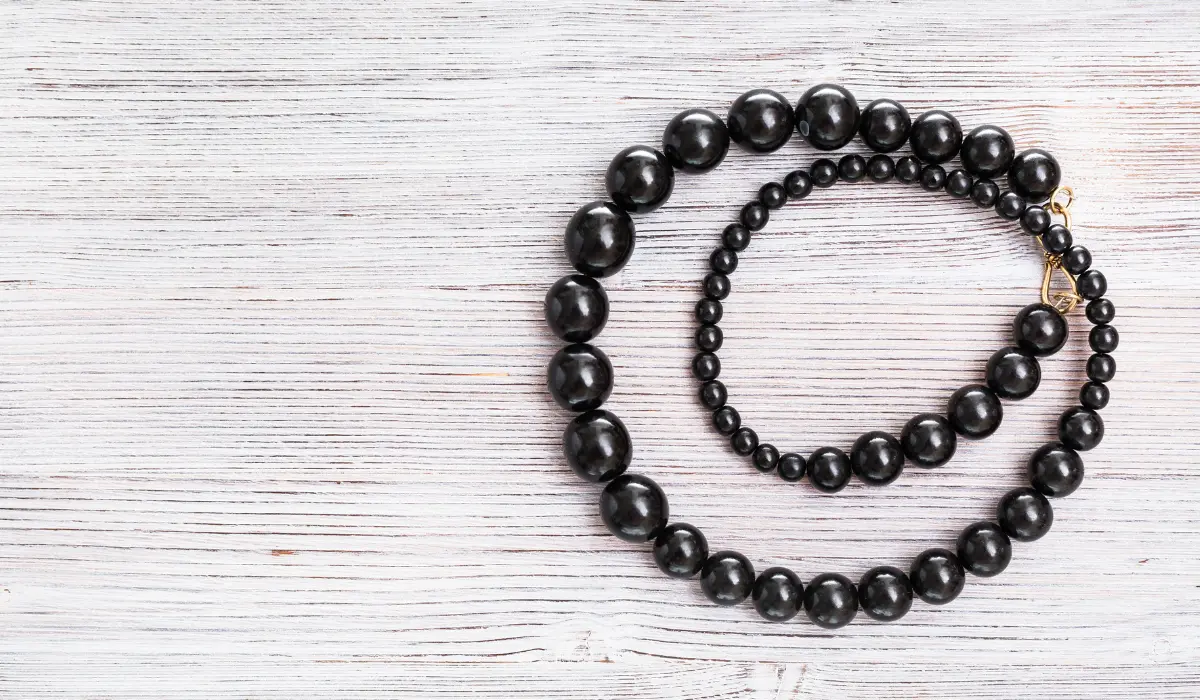 collier composé de perles de gagate posé sur une table