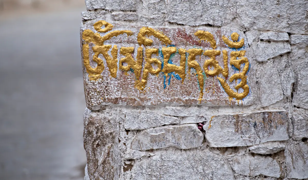 Om Mani Padme Hum écrit sur un mur avec l'alphabet tibétain