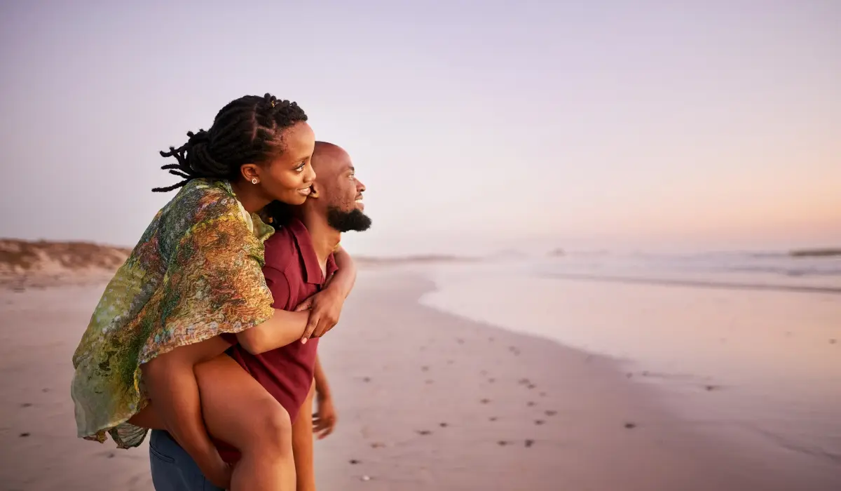 un couple sur une plage, qui regarde au loin