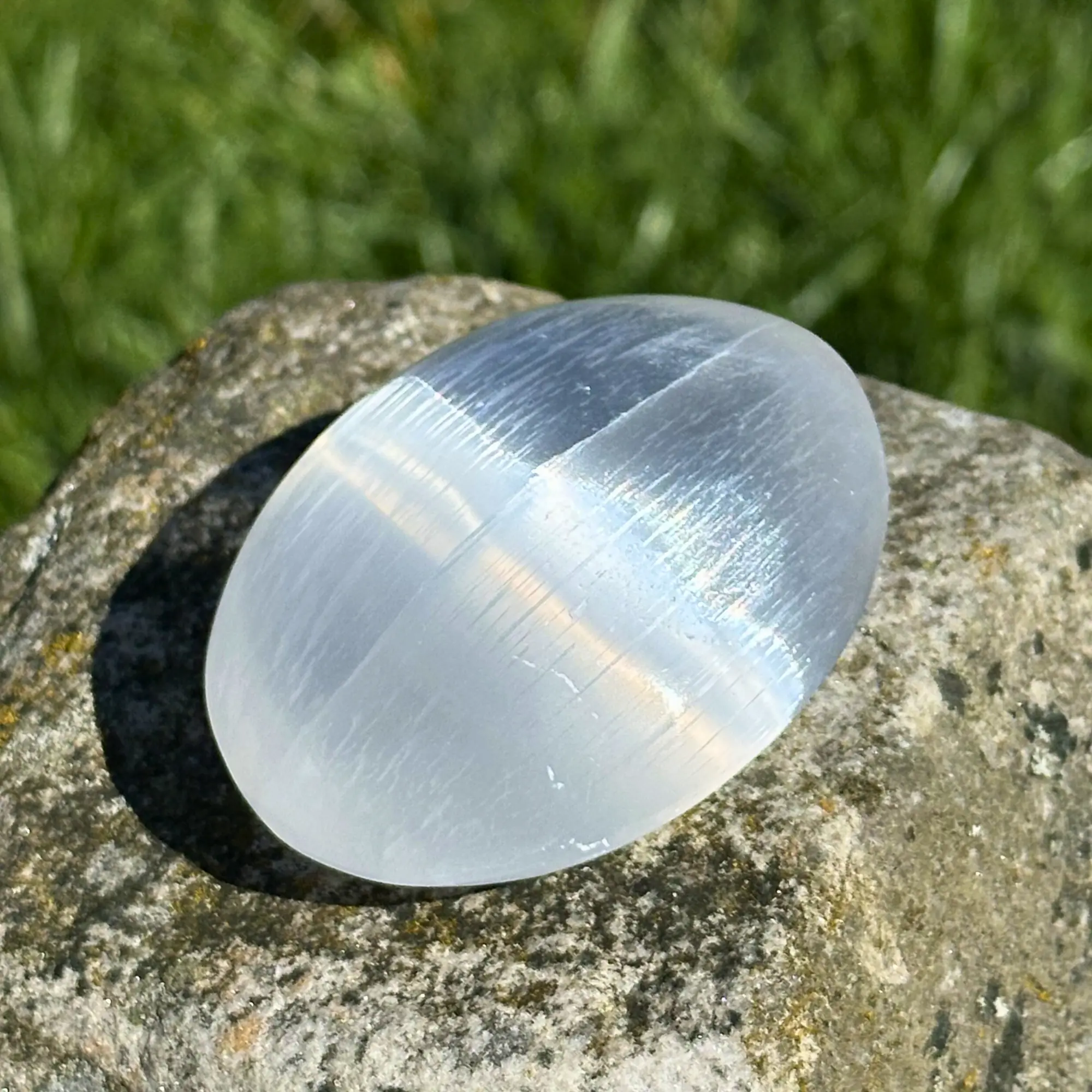 galet de sélénite posé sur un rocher
