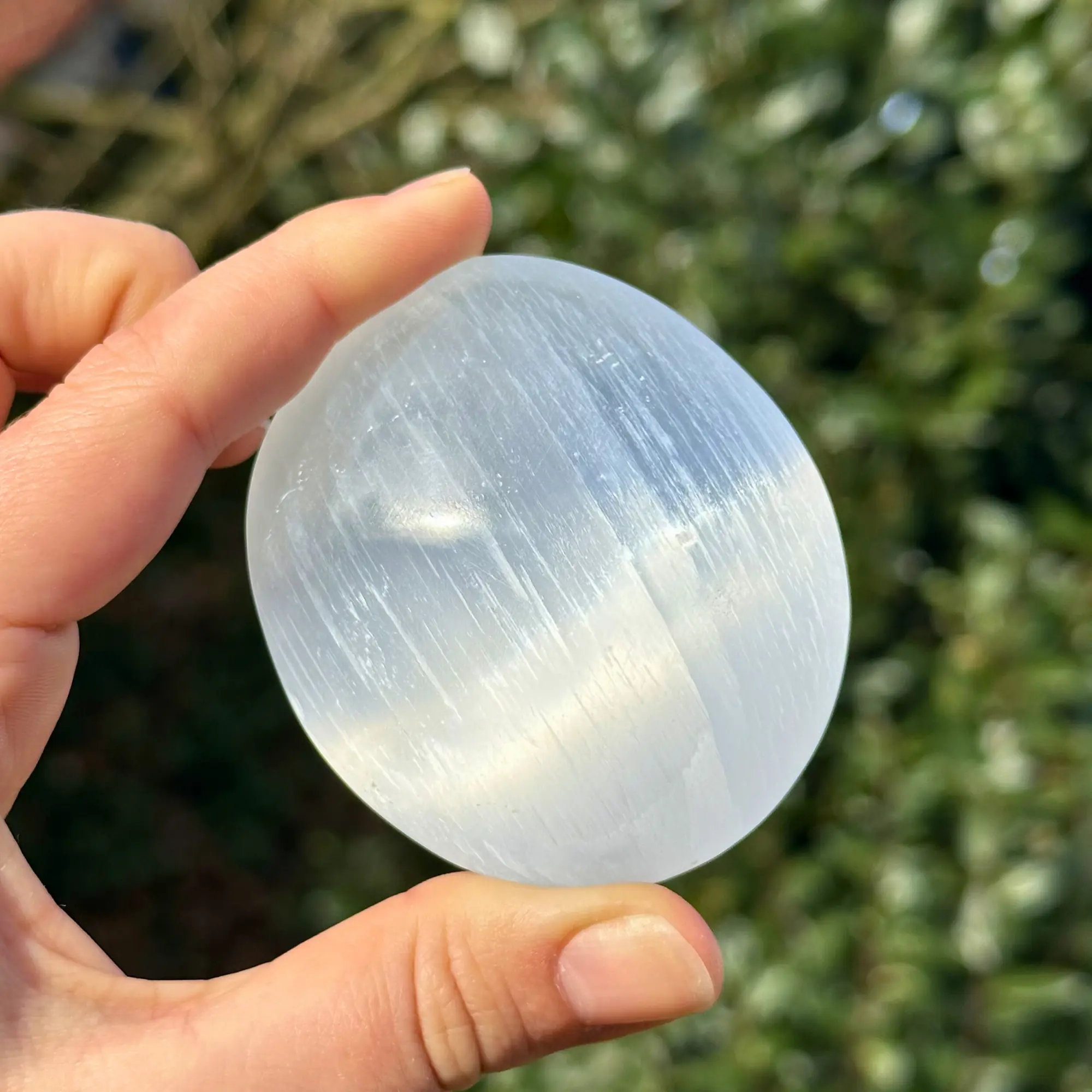 galet de sélénite tenu entre les doigts