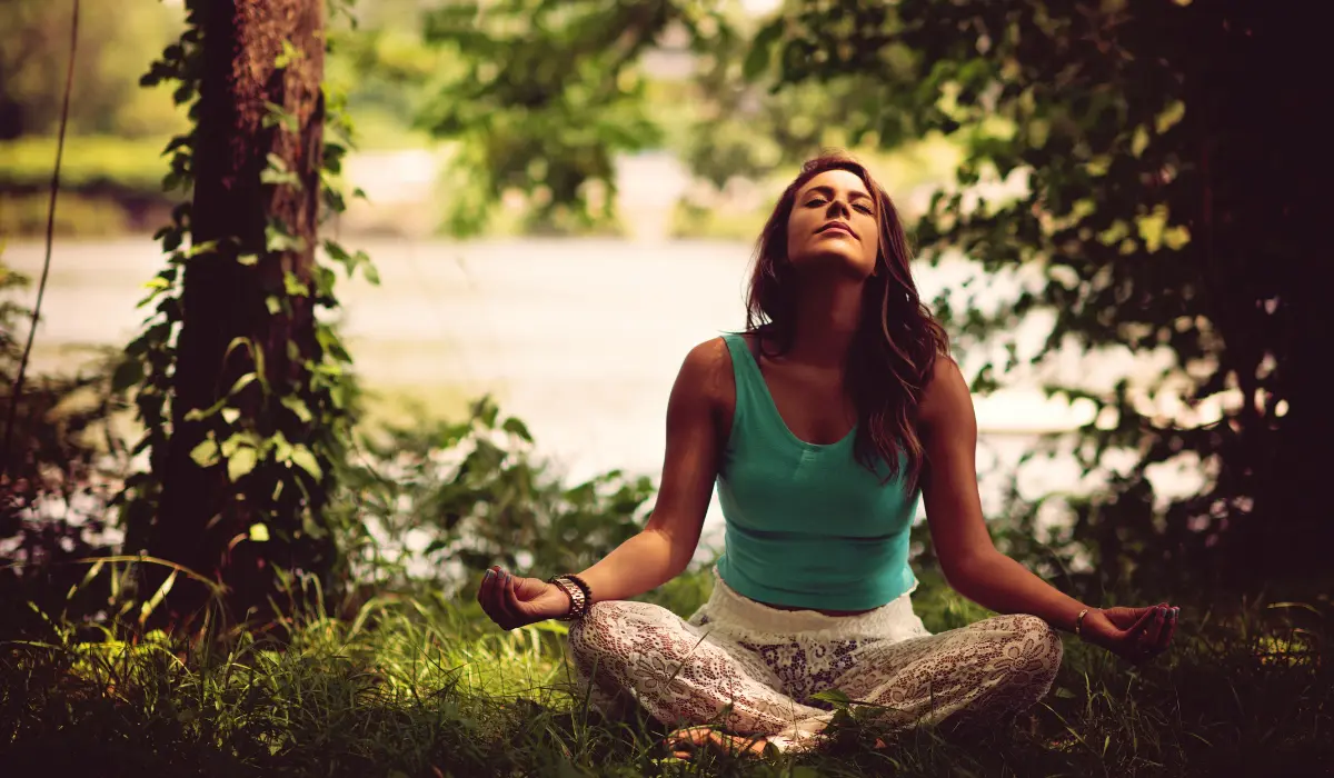 jeune femme en train de méditer dans la nature
