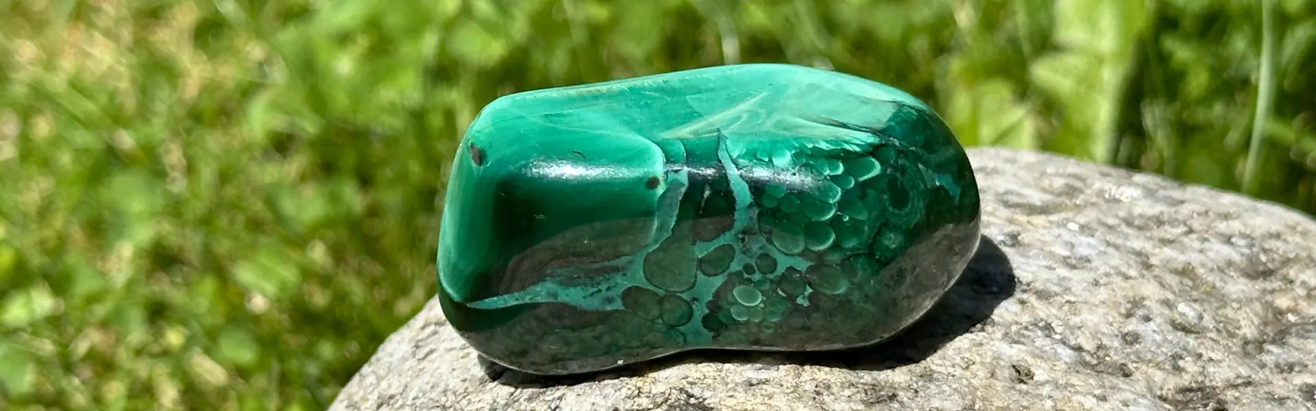 Malachite rouléee posée sur un rocher