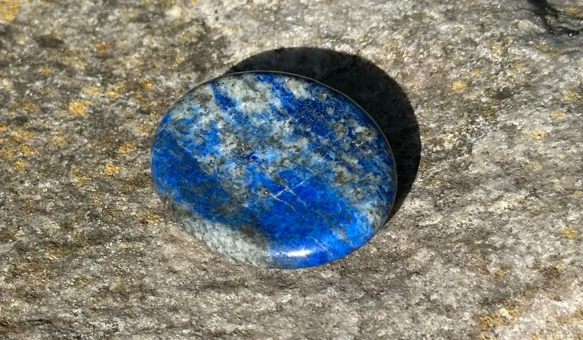 Galet anti-stress de lapis-lazuli posé sur un rocher