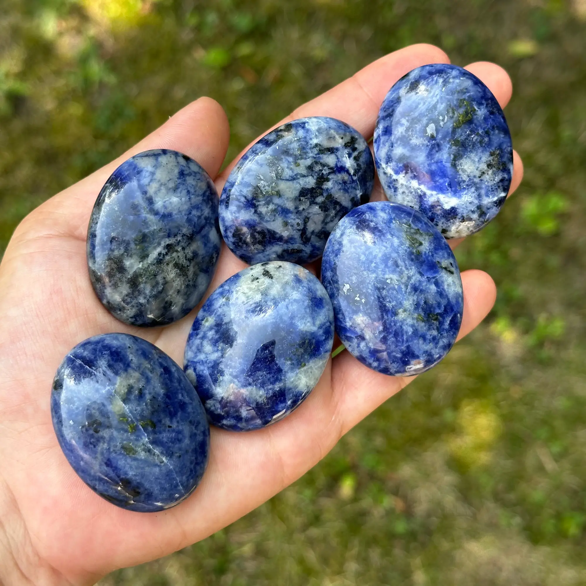 galet sodalite tenu dans la main