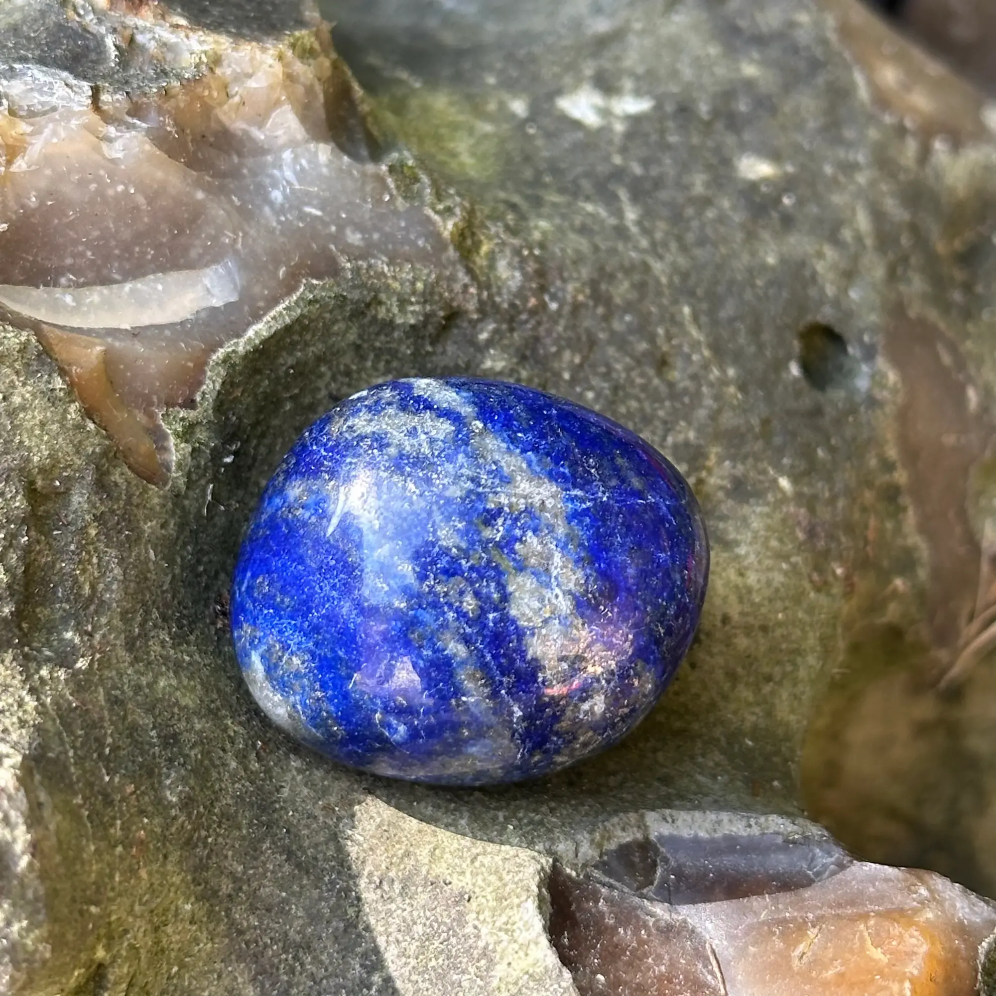 lapis lazuli roulé en gros plan posé sur un rocher