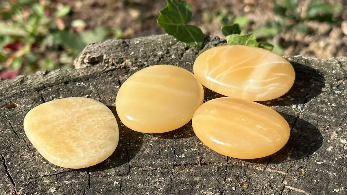 Quatre galets calcite orange sur un rocher